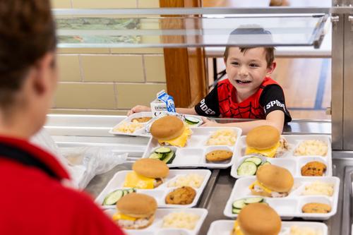 A student collects lunch in the lunch line